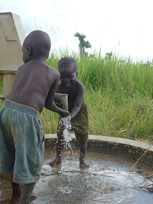 kids pumping clean water from newly repaired well